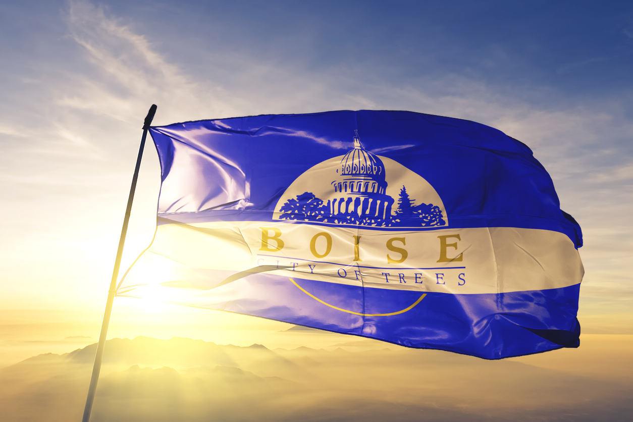 Boise city capital of Idaho of United States flag on flagpole textile cloth fabric waving on the top sunrise mist fog